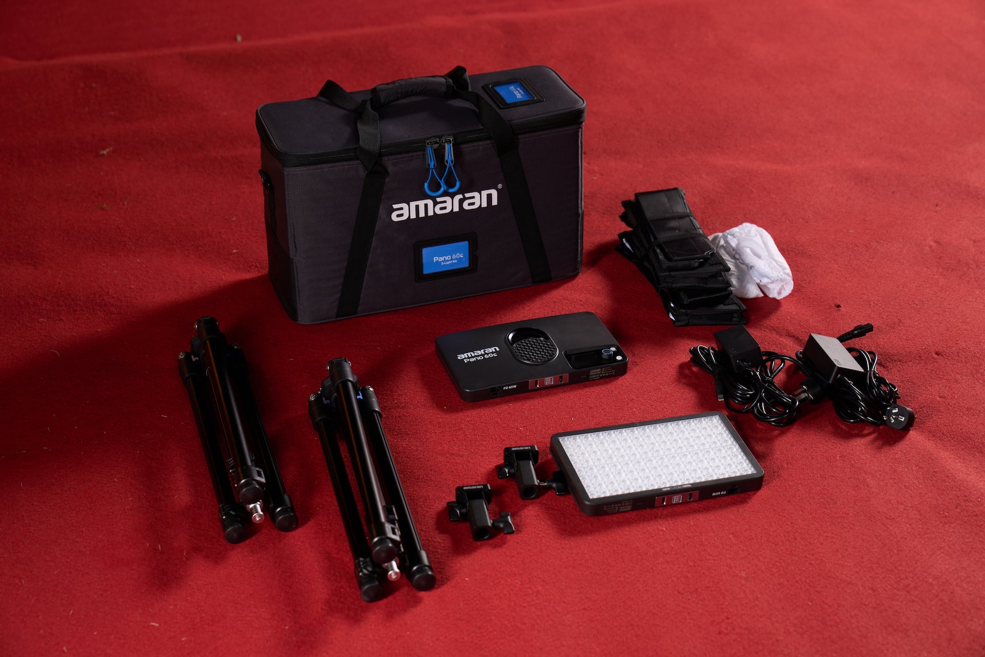 All components included in the amaran Pano 60c 2 Light Kit, on a red carpet.