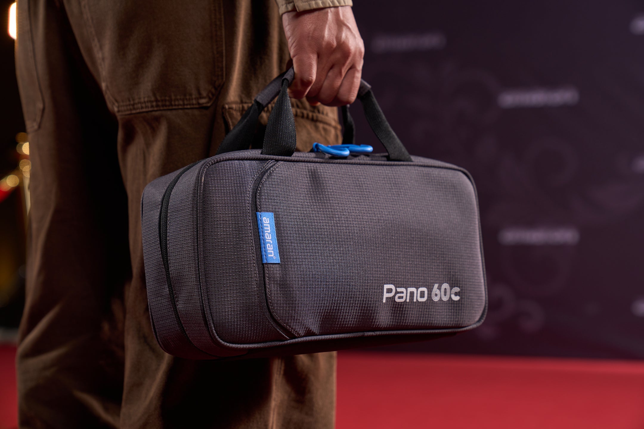 A man carrying an amaran Pano 60c case.