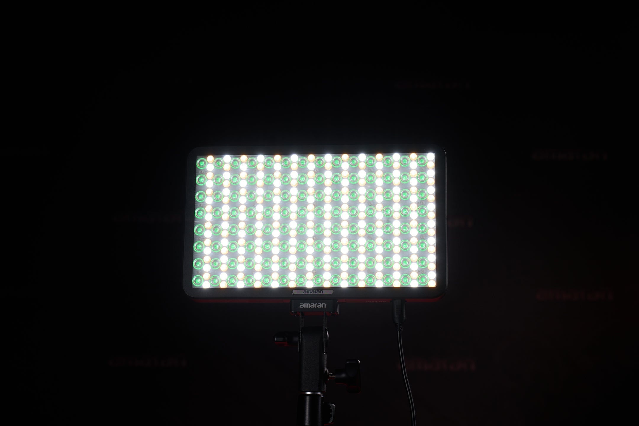 Front view of an amaran Pano 60c illuminating green and white lights.