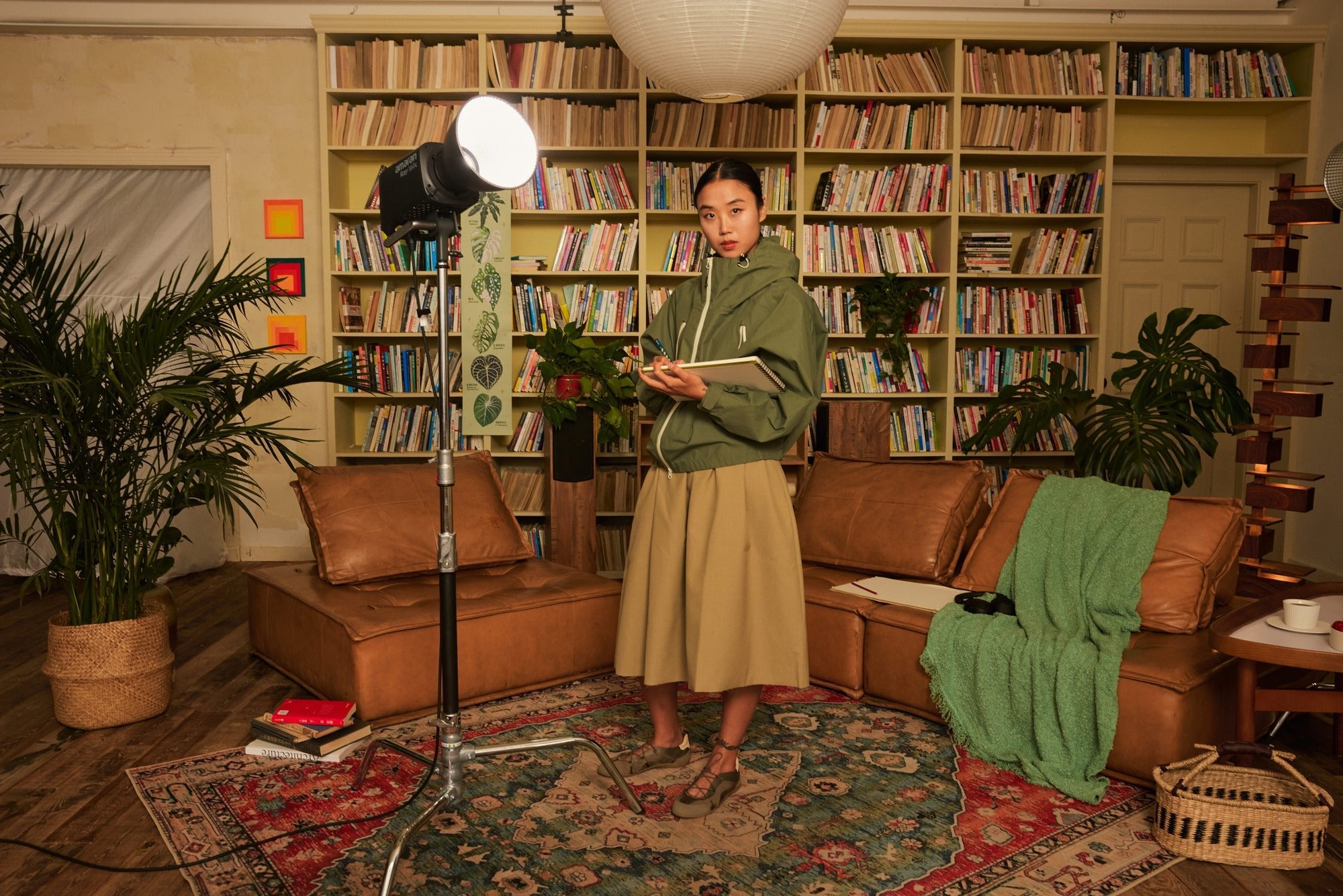 A woman standing in a living room with an amaran Ray 360c being used.
