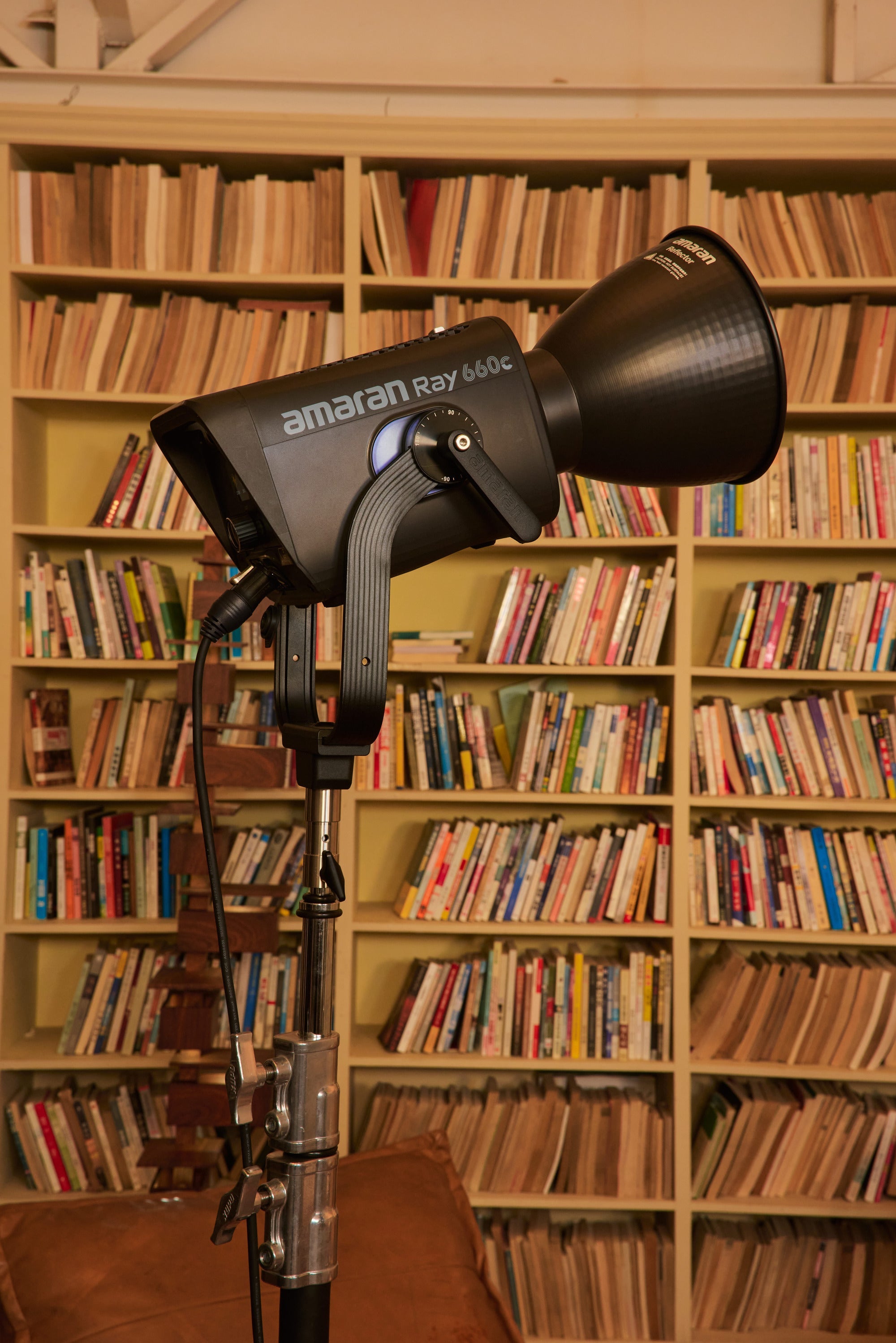 amaran Ray 660c LED Light shown with a bookcase in the background on a photoshoot.