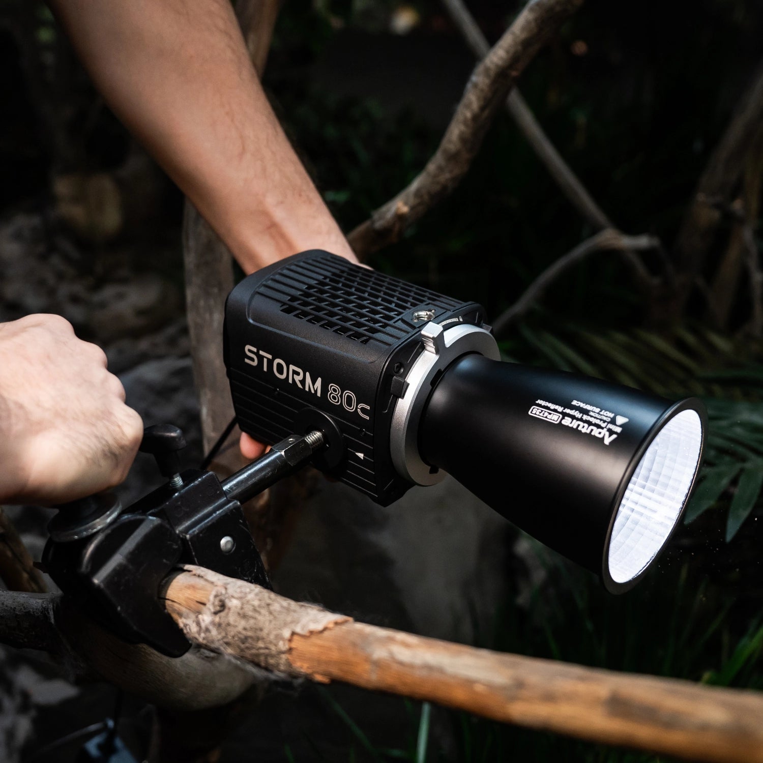 Aputure 80c being rigged on a superclamp in a outdoors.