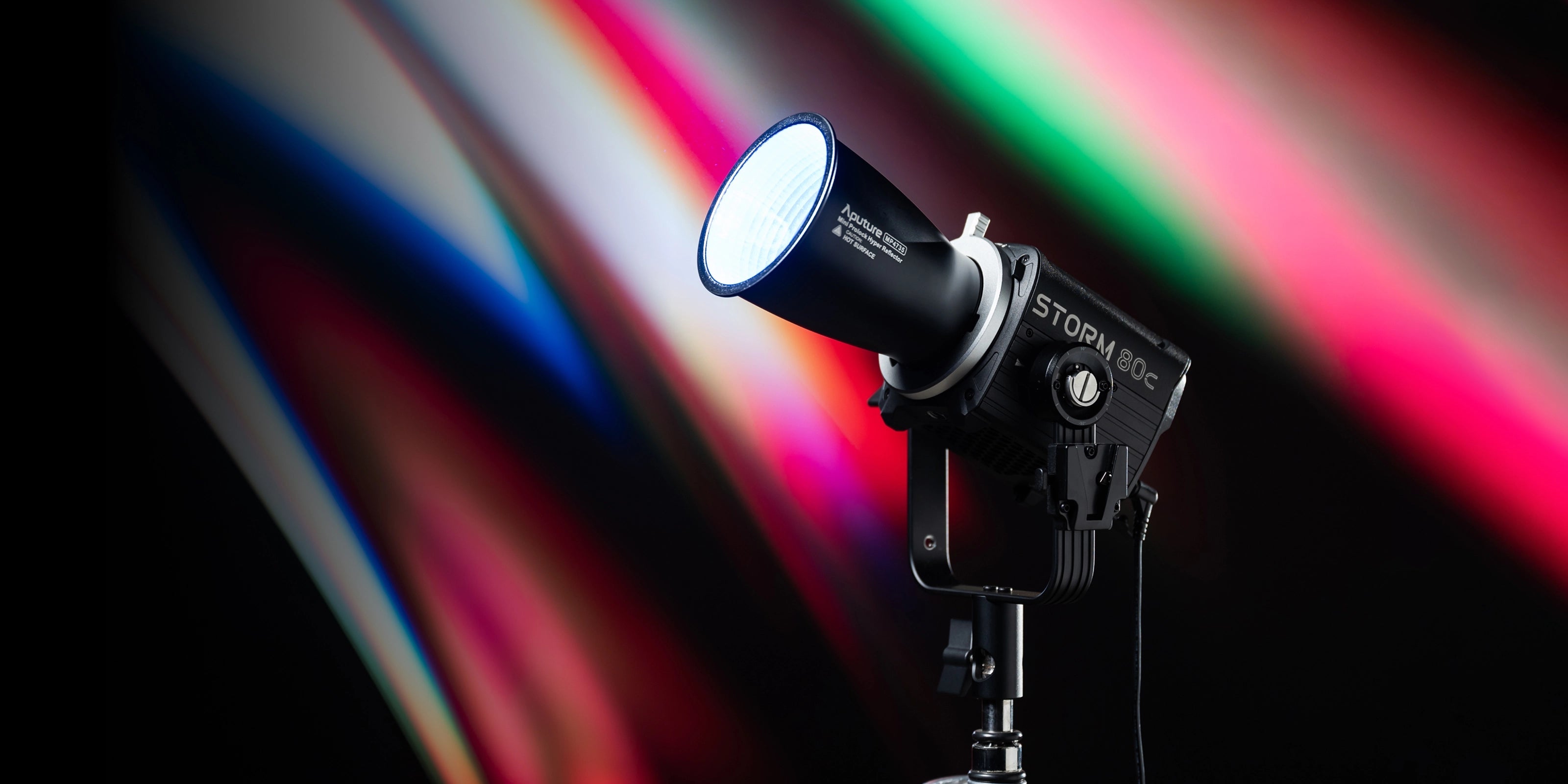 Aputure Storm 80c Head and Mini Prolock Hyper Reflector on a coloured background.