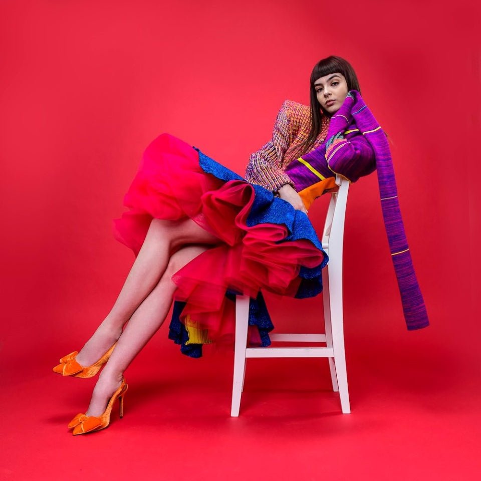 Portrait of a Female Model being photographed with a Colorama Cherry Seamless Background Paper.