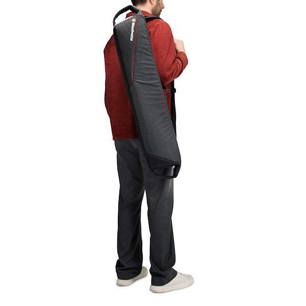 A man carrying a Manfrotto Pro Light Tripod Bag 80 on his bag, showing its portability.