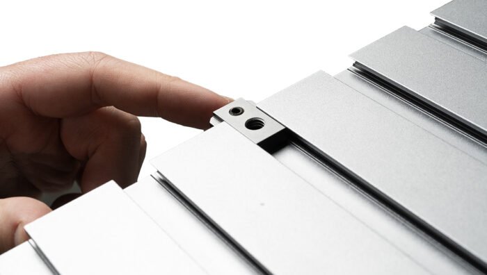 A person introducing a Tether Tools AeroTrac 1/4"-20 Accessory Thread to the workstation.