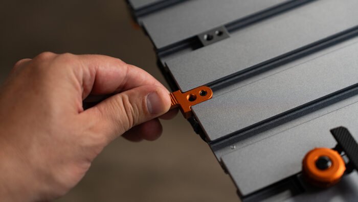 A person introducing the Tether Tools AeroTrac Action Tabs (pair of 2) on a workstation.