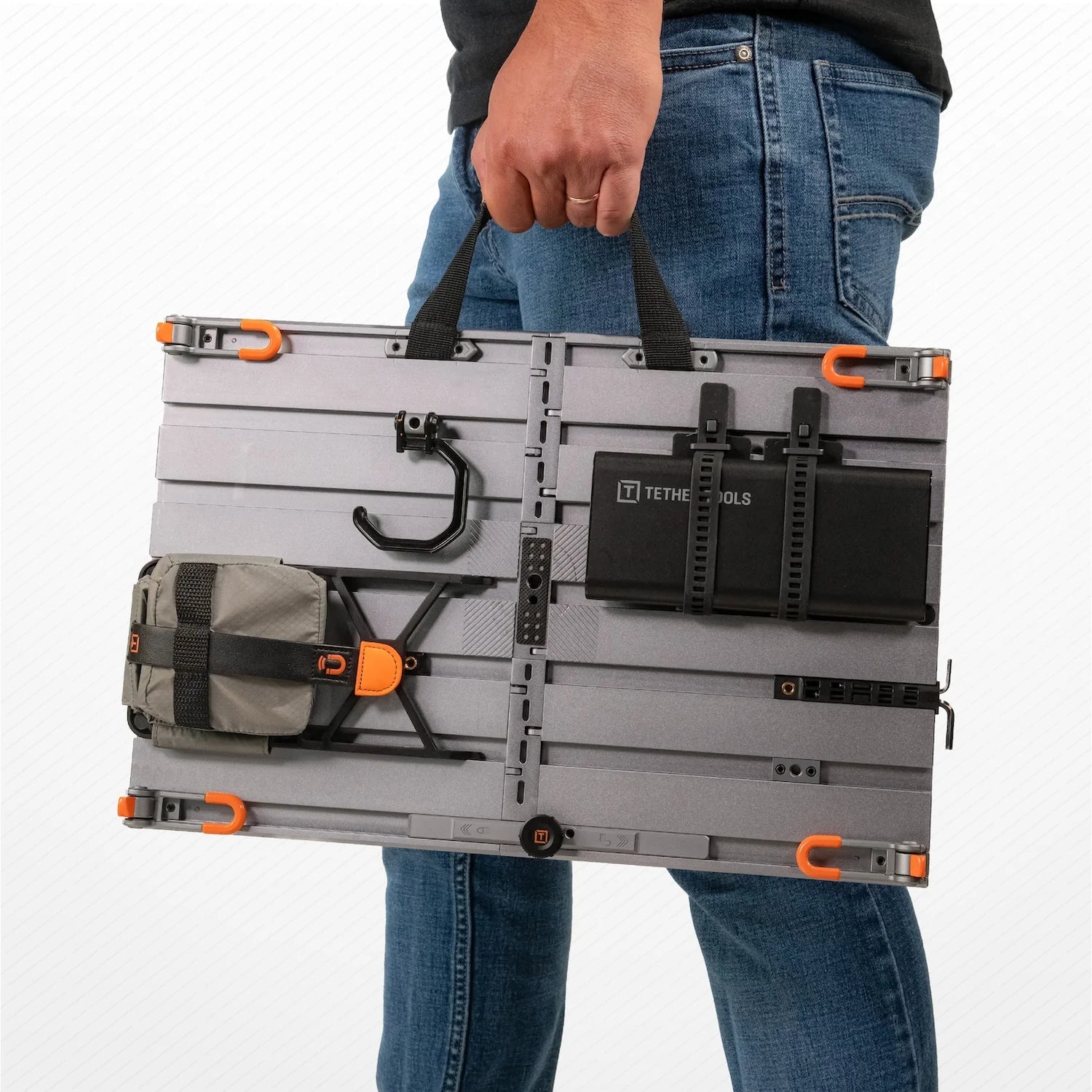Person holding the Configuration Tool with Tether Tools AeroTrac Workstation Legs (set of 4) attached.