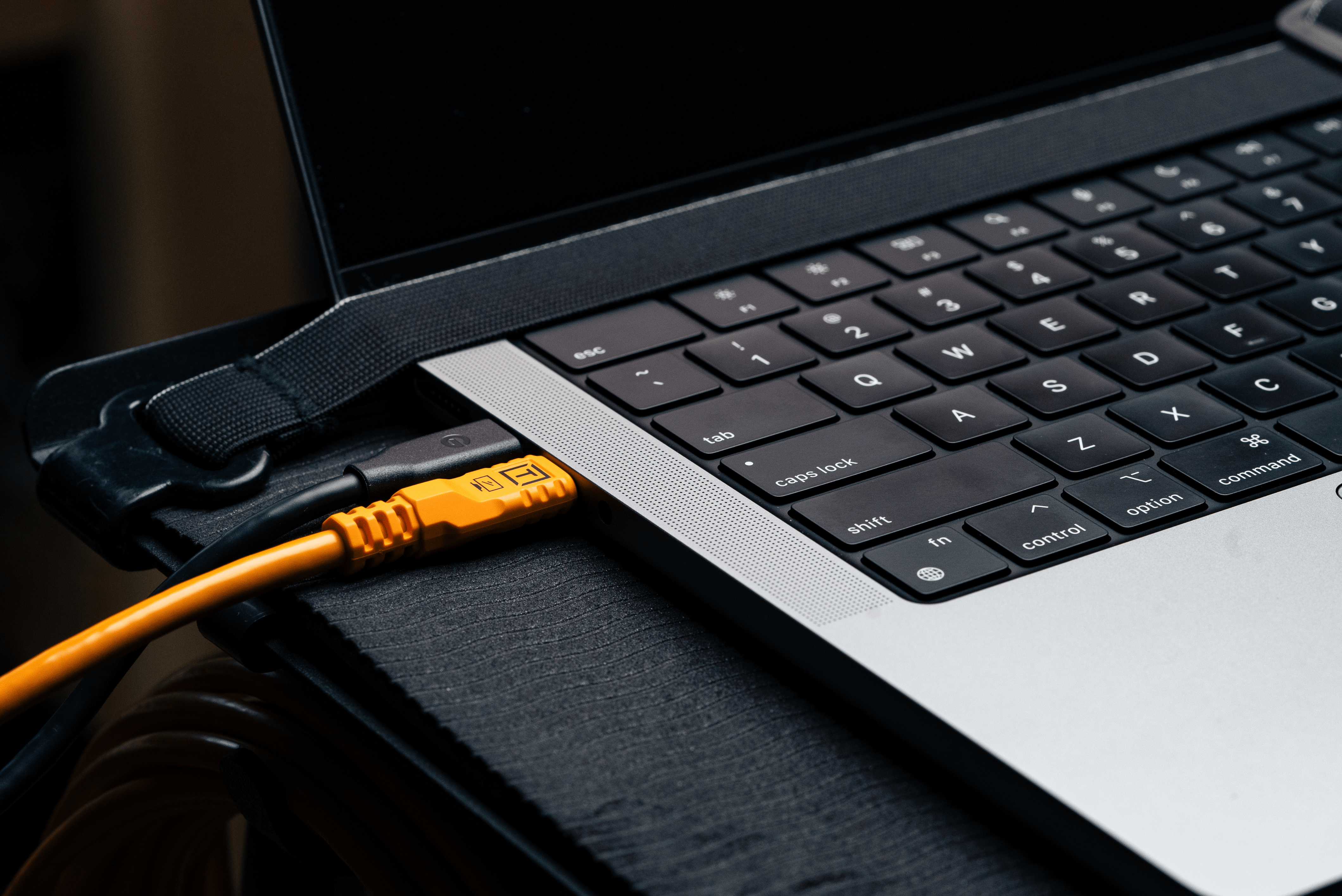 Tether Tools TetherPro Optima 10G USB-C, 10' (3m), Straight to Straight, High-Visibility Orange connected to a computer.