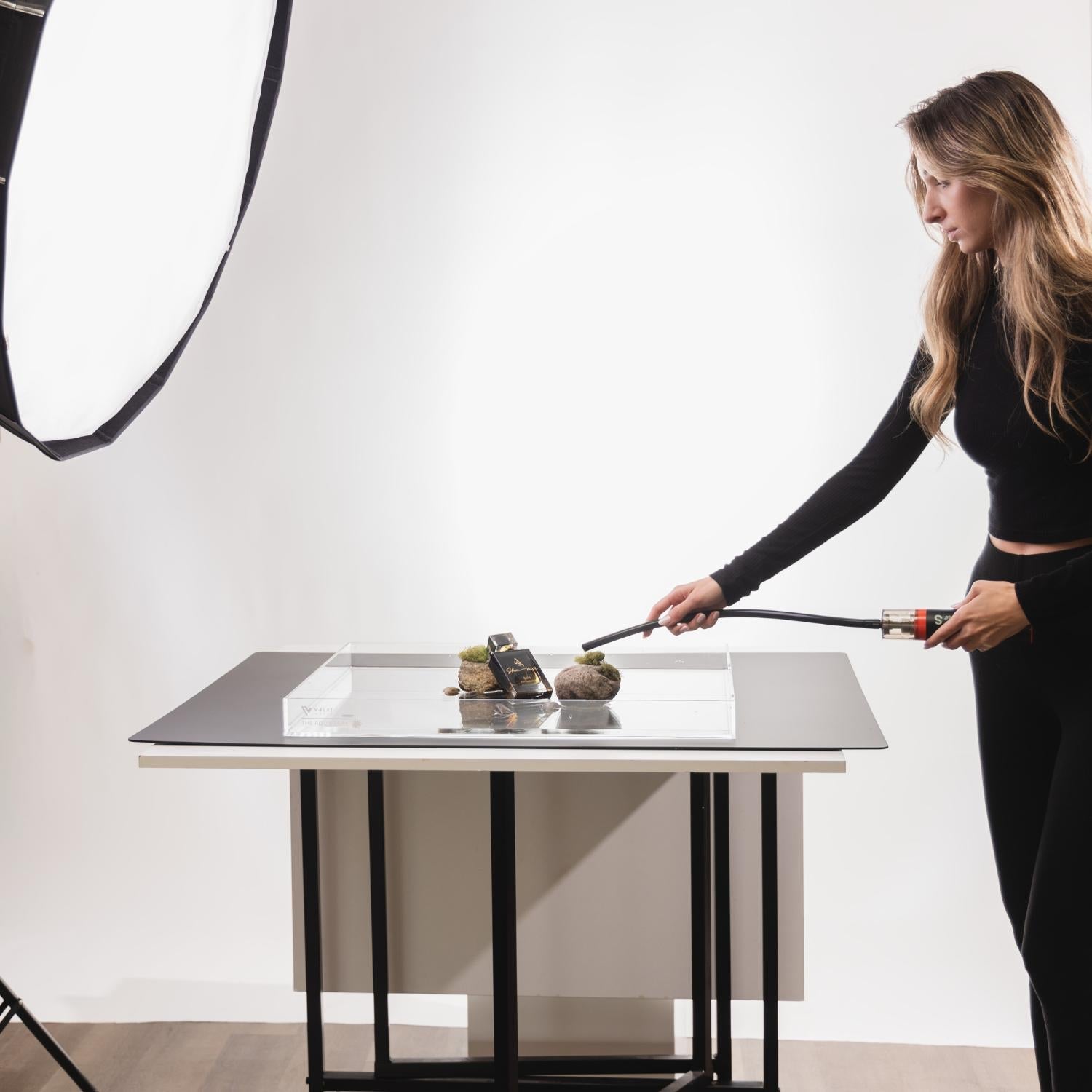 A person setting up a photoshoot using a V-Flat Aqua Tray (16"x12").