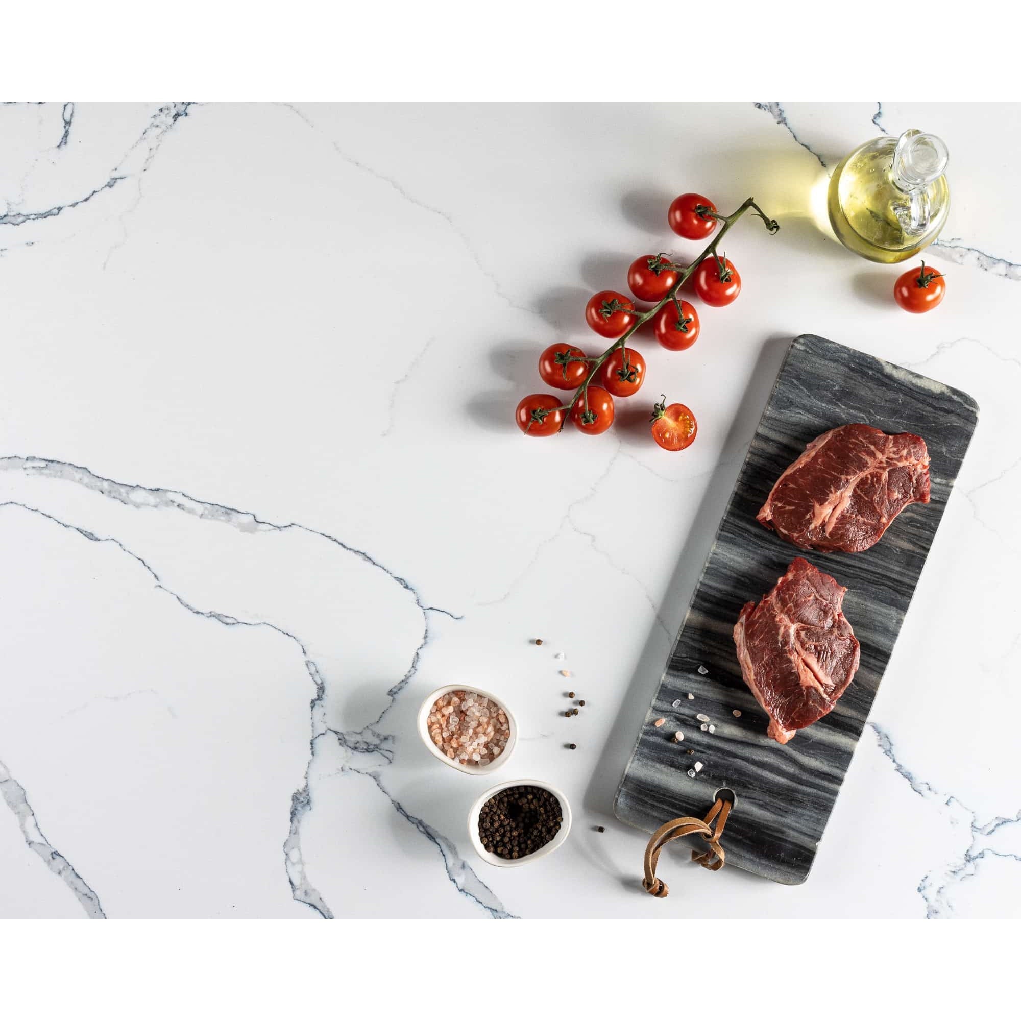V-Flat Carrara Blue/Calacatta Gold Duo Board picturing some steak and tomatoes.