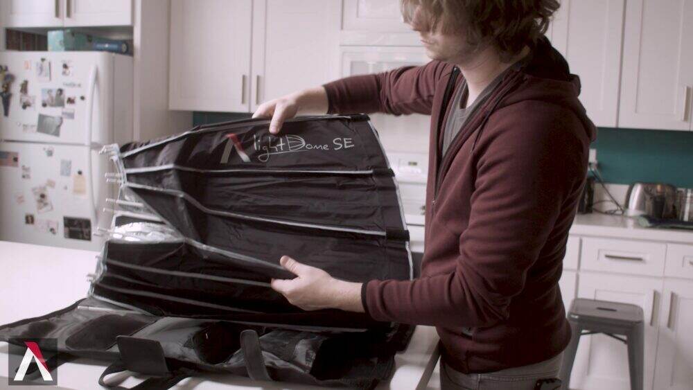 Photographer showing the softbox folded into its compact and travel-friendly form.