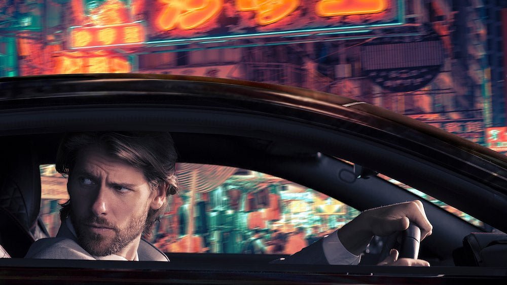 Image of the man in the car with an overlaid image replacing the green screen.