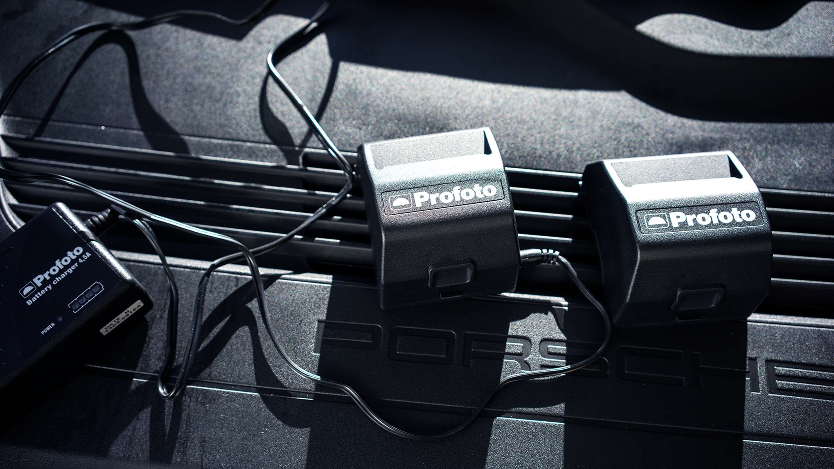 Two Profoto B1X & B1 Li-Ion Battery MkII's pictured with a battery charger.