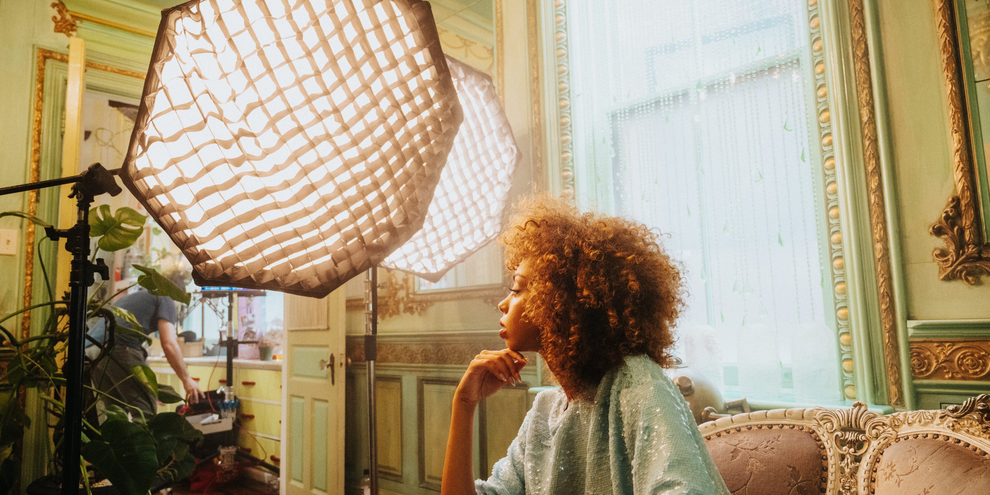 Woman sitting on sofa lit by Profoto lighting