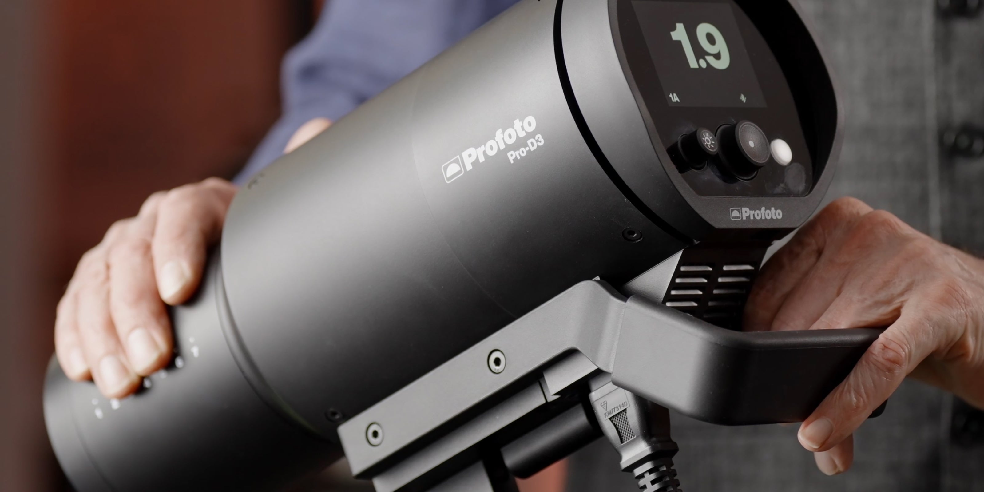 Photographer holds the Profoto Pro-D3 which is being set up for a photo shoot.