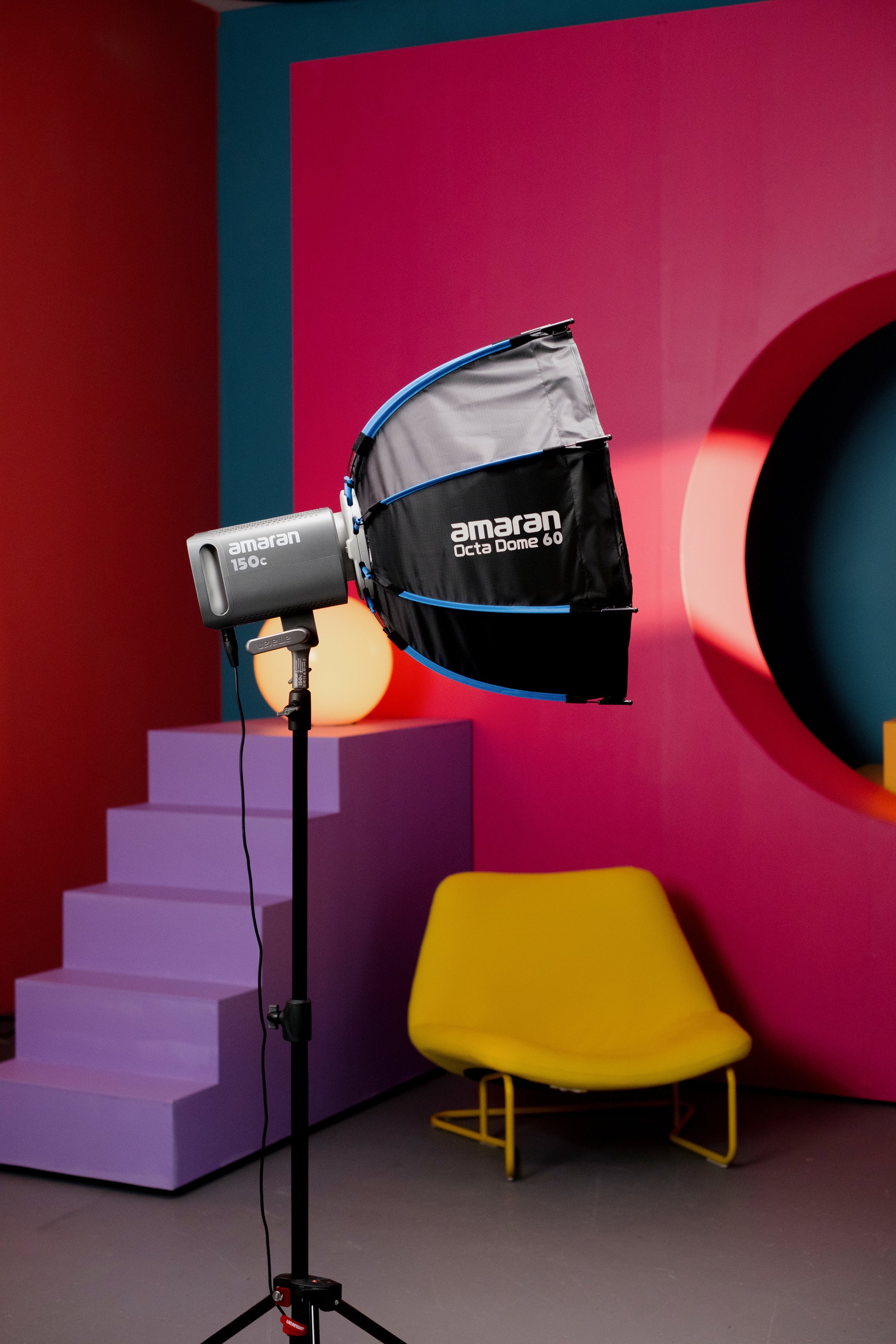 amaran Octa Dome 60 shown in a studio environment connected to a 150c  on a light stand with a colourful background. 