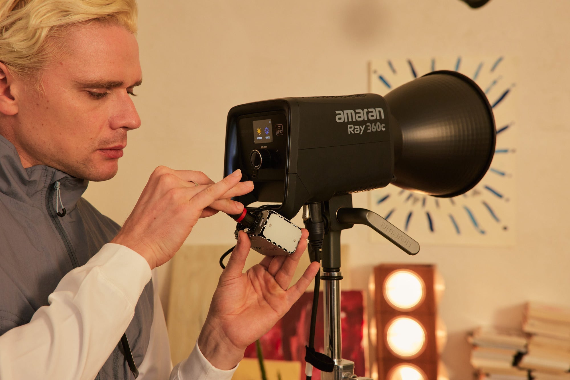 Person adjusting the settings for the amaran Ray 360c Light.