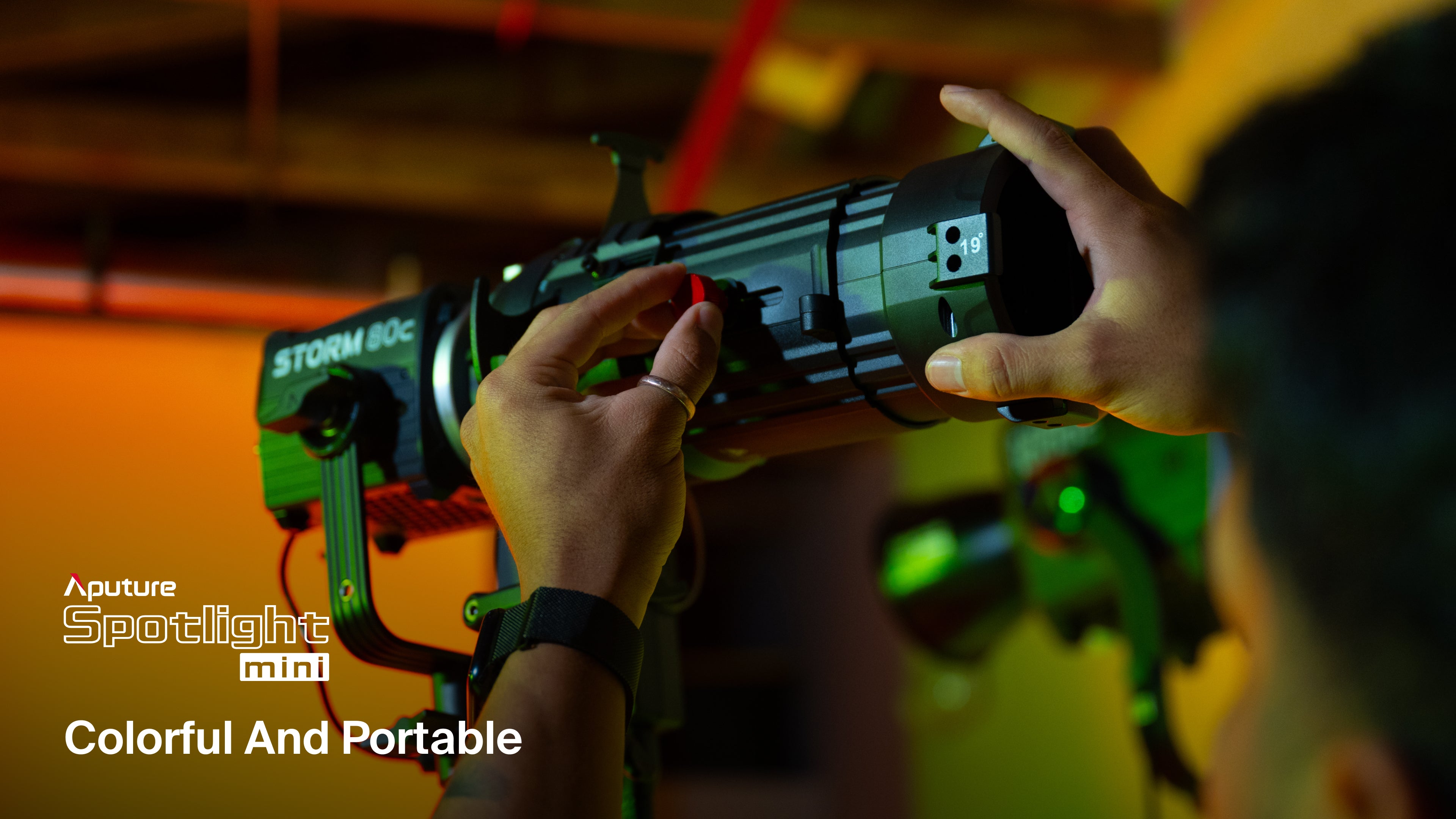 A technician altering the connection between an Aputure Storm 80c and the Aputure Spotlight mini lens 19°.