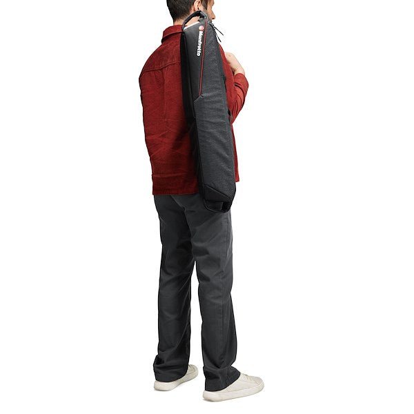 A man carrying the Manfrotto Pro Light Tripod 69 on his back showing its portability. 