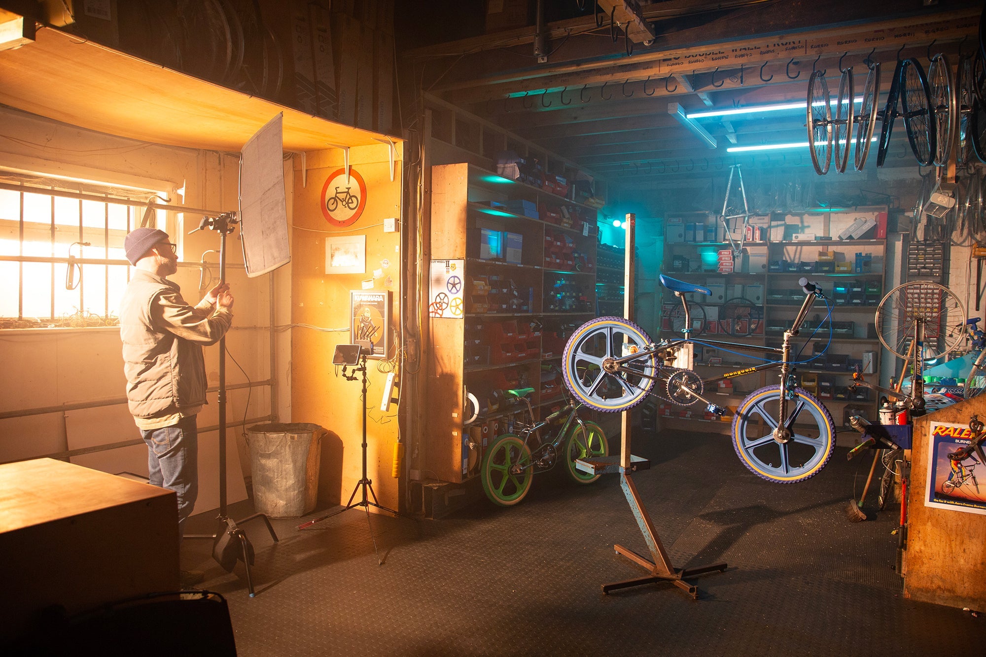 Inside a bike repair shop, showing a lighting technician setting up the 18x24"  Rapid Flag frame and fabric.