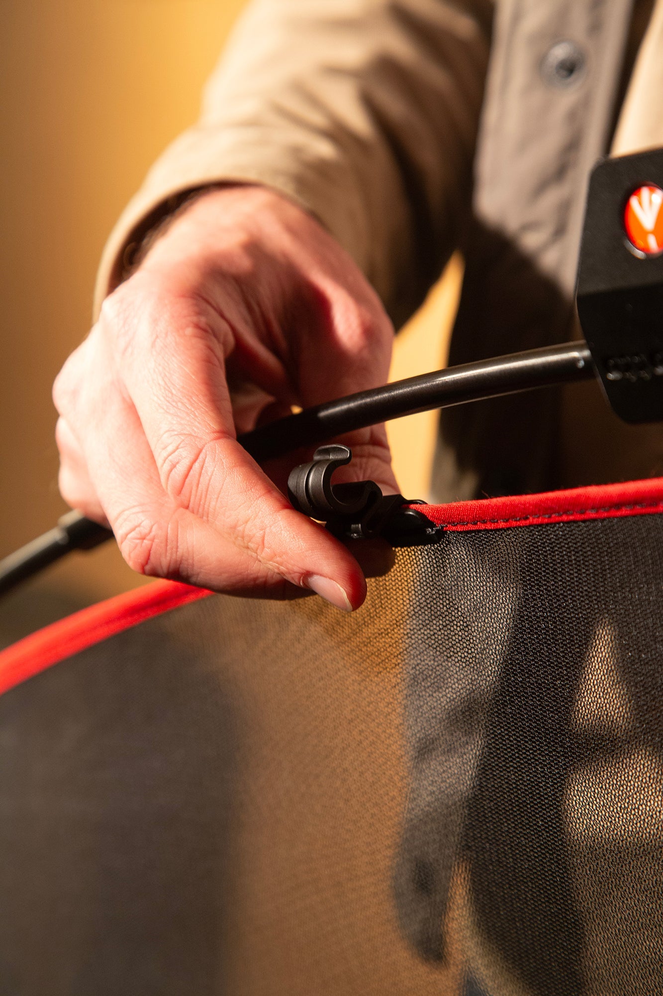 A lighting technician assembling the LL LR1912 Rapd Flag kit with Single Net being clipped onto the metal frame. 