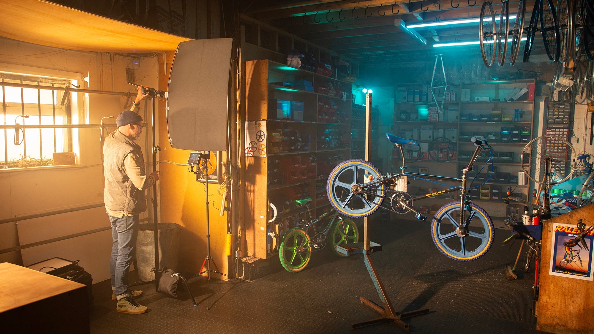 Inside a bike repair shop, showing a lighting technician setting up the Rapid Flag frame and fabric.