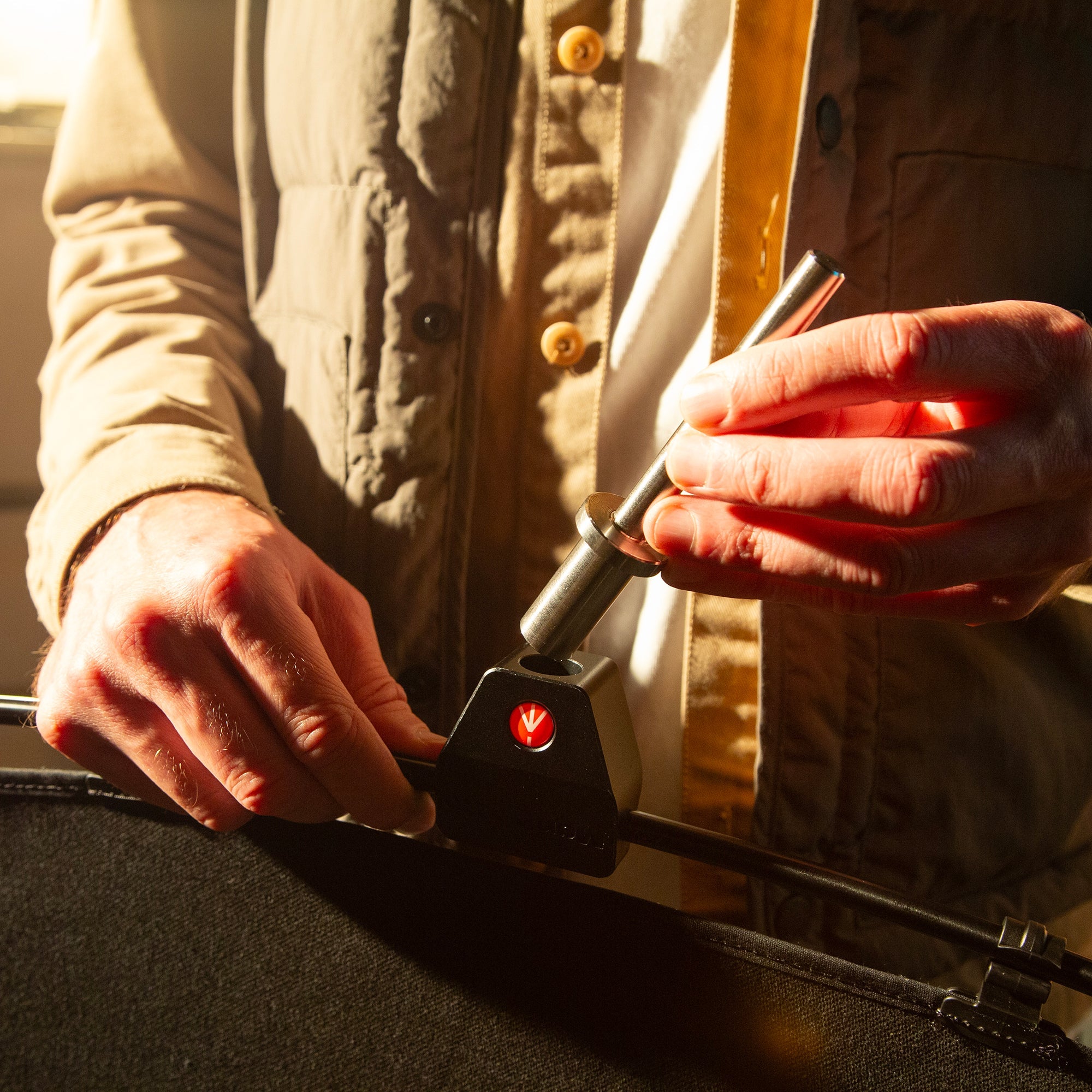 A lighting technician placing the  Grip Head Mounting Pin into place. 