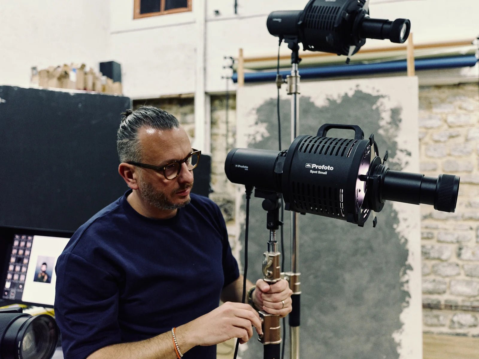 Photographer in a studio using two Profoto Spot Small modifiers.