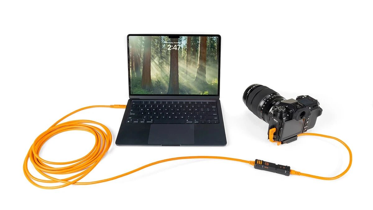 Tether Tools TetherPro Optima 10G USB-C, 20” (51cm), Straight to Right Angle Adapter “Pigtail” Cable, High Visibility Orange connected to a laptop and camera.