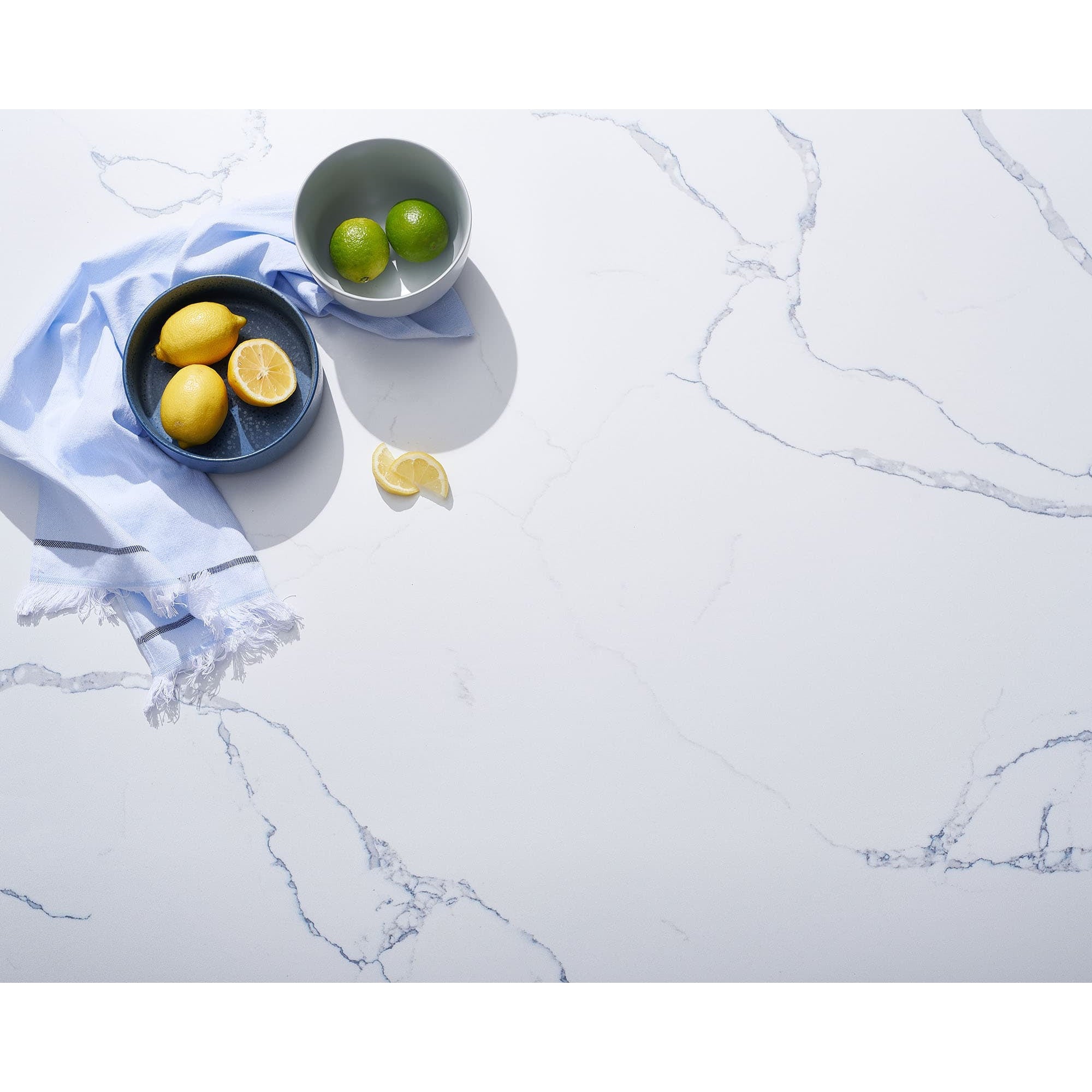 Birds eye view of a V-Flat Carrara Blue/Calacatta Gold Duo Board as a background, capturing some fresh fruit.