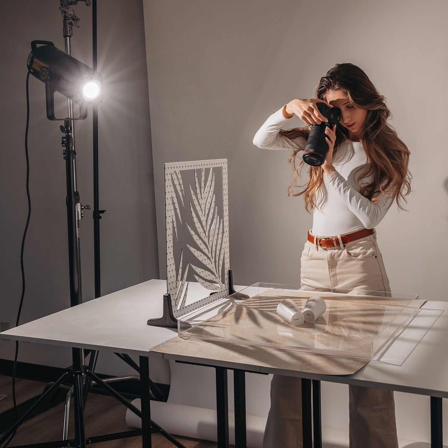 A studio setup with a light being controlled by the V-Flat Palm Leaf.