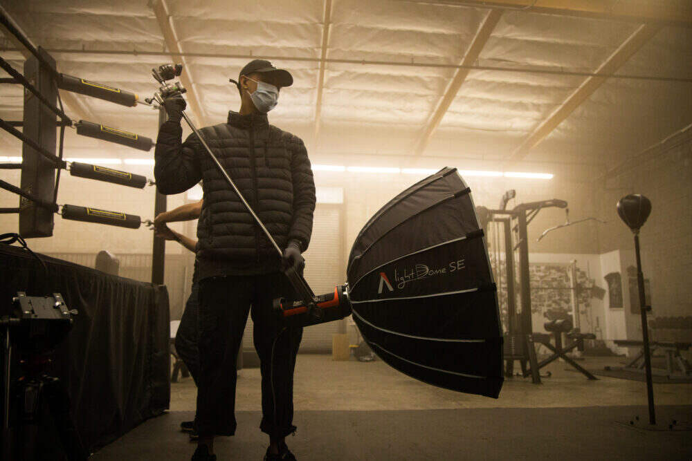 Softbox being controlled by a lighting technician in a gym environment.