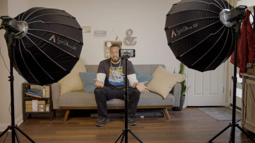 Presenter demonstrating how to use two Aputure softboxes whilst filming.