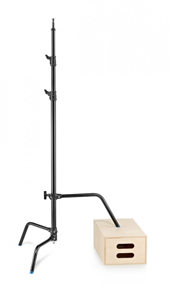 Avenger C-Stand Sliding Leg 40'' Black 3.3m/10.8' Base & Column (A2033LCB) shown with the sliding leg raised up the column and resting on an apple box