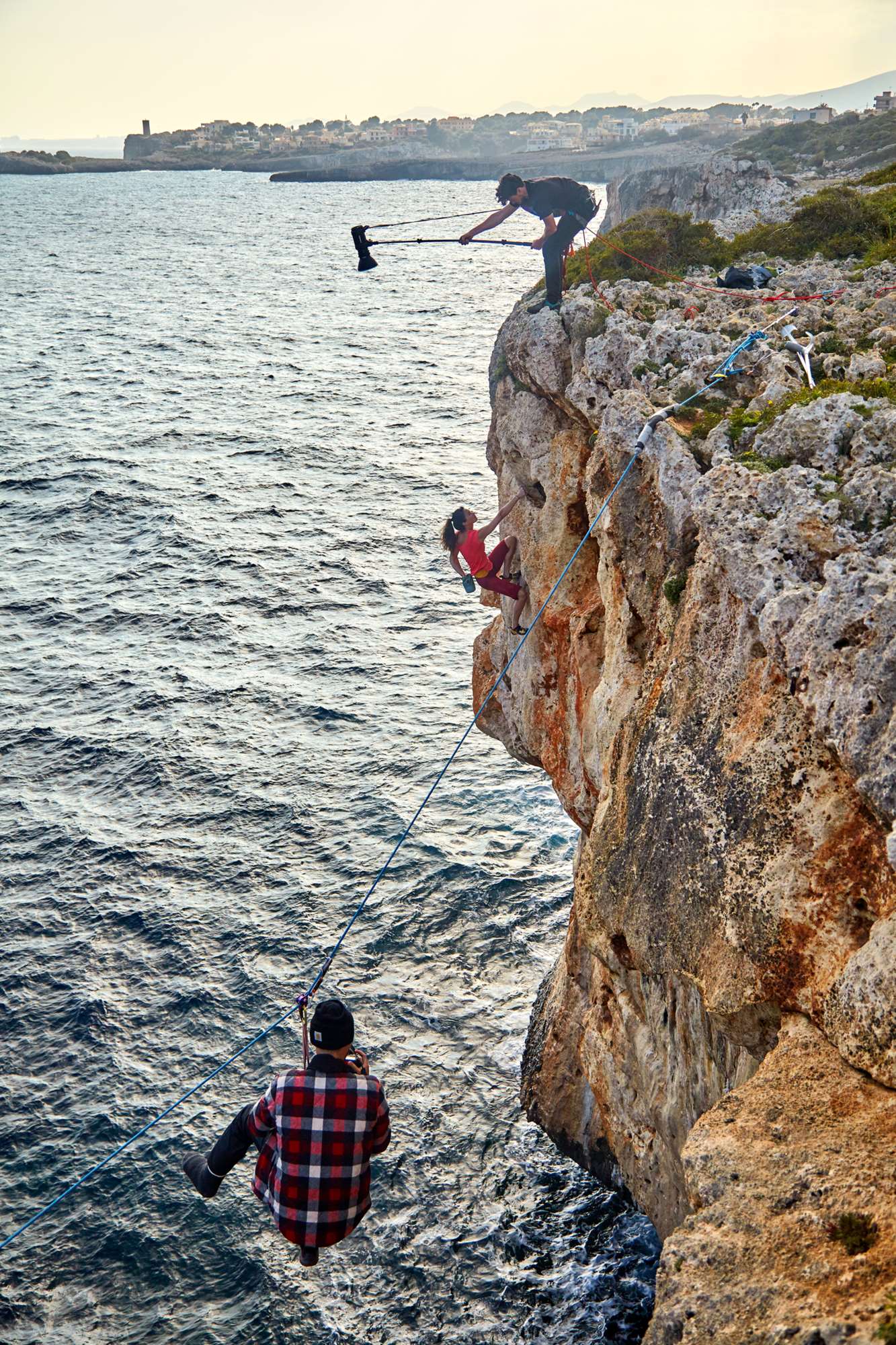 OCF Magnum Reflector being dangled over a cliff on a location shoot of a rock climber