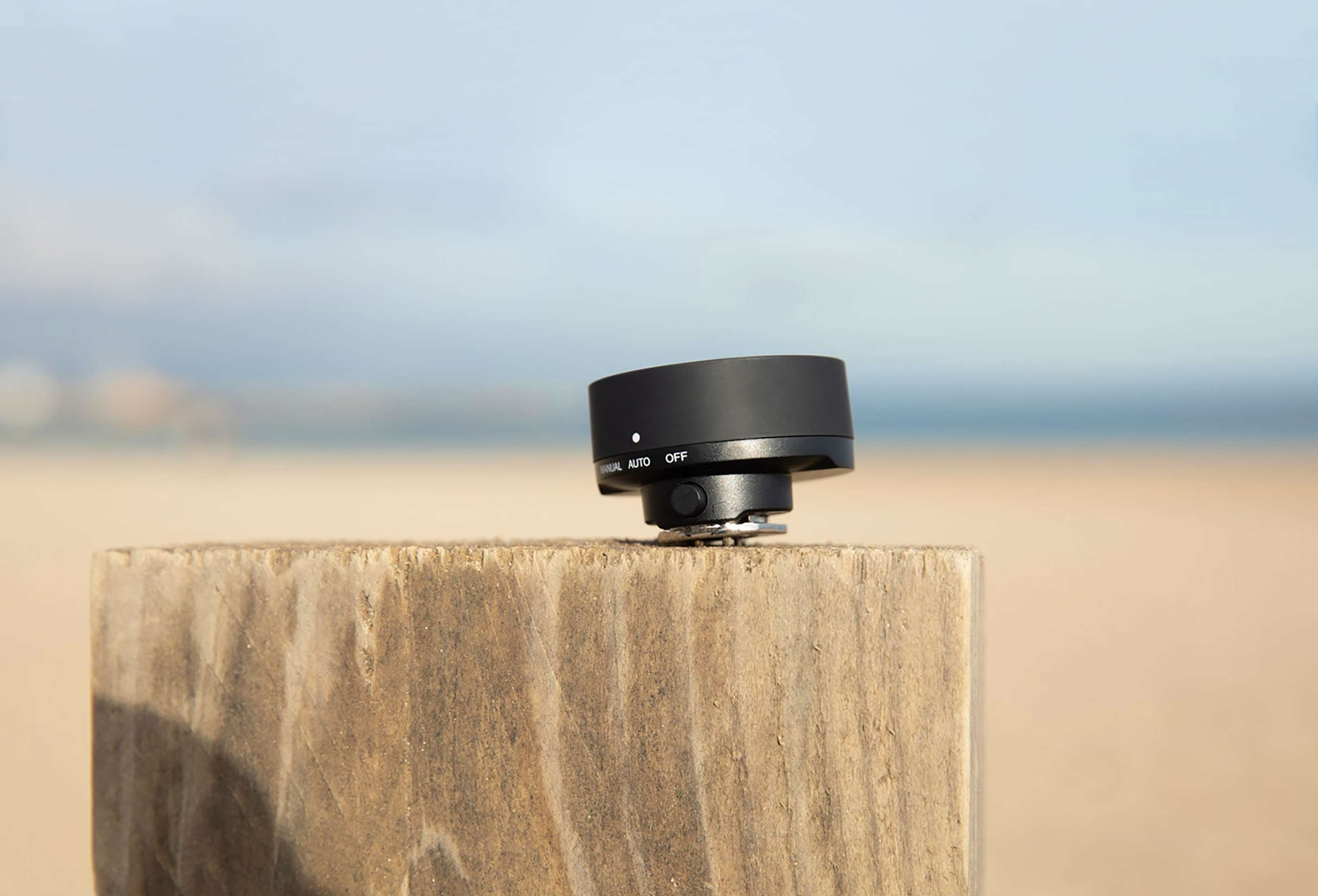 The Profoto Connect relaxing on a wooden post by the beach whilst having its photo taken